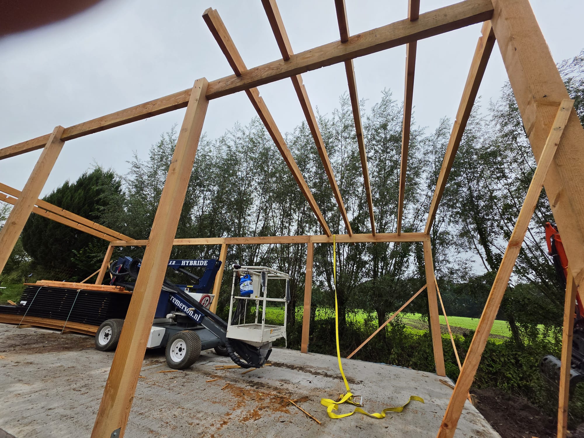 Dakspanten en kepers opgesteld in het houten skelet van de schuur