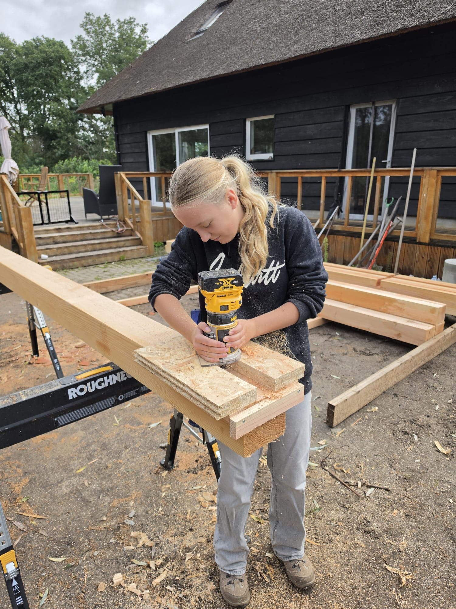 Stagiair van Cremers BBG freest een verbinding in een houten ligger